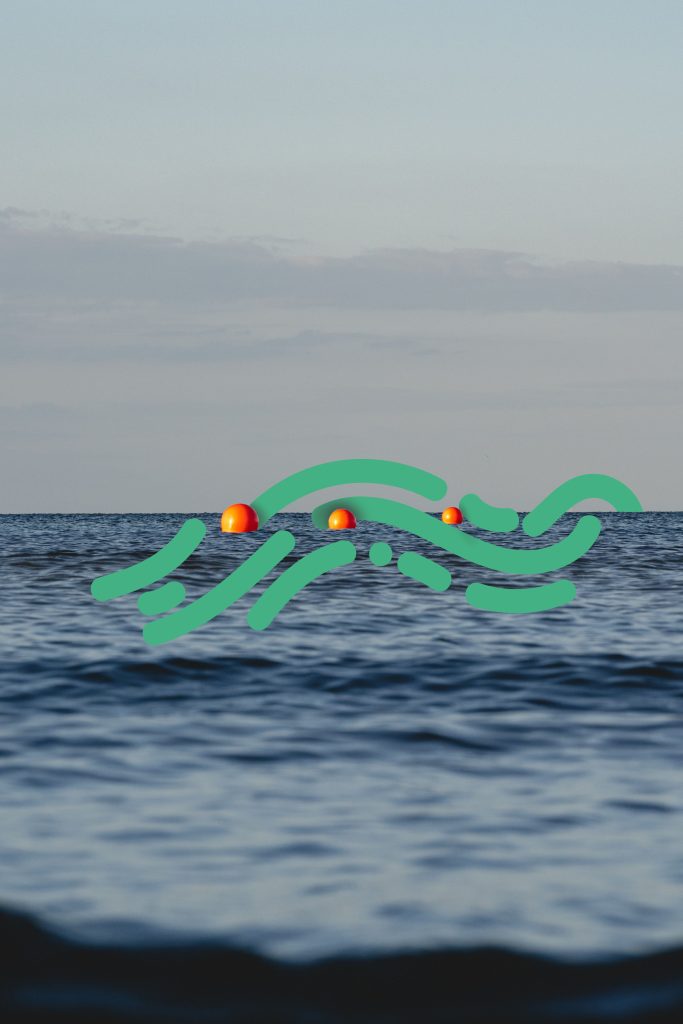 Three orange buoys floating on the sea